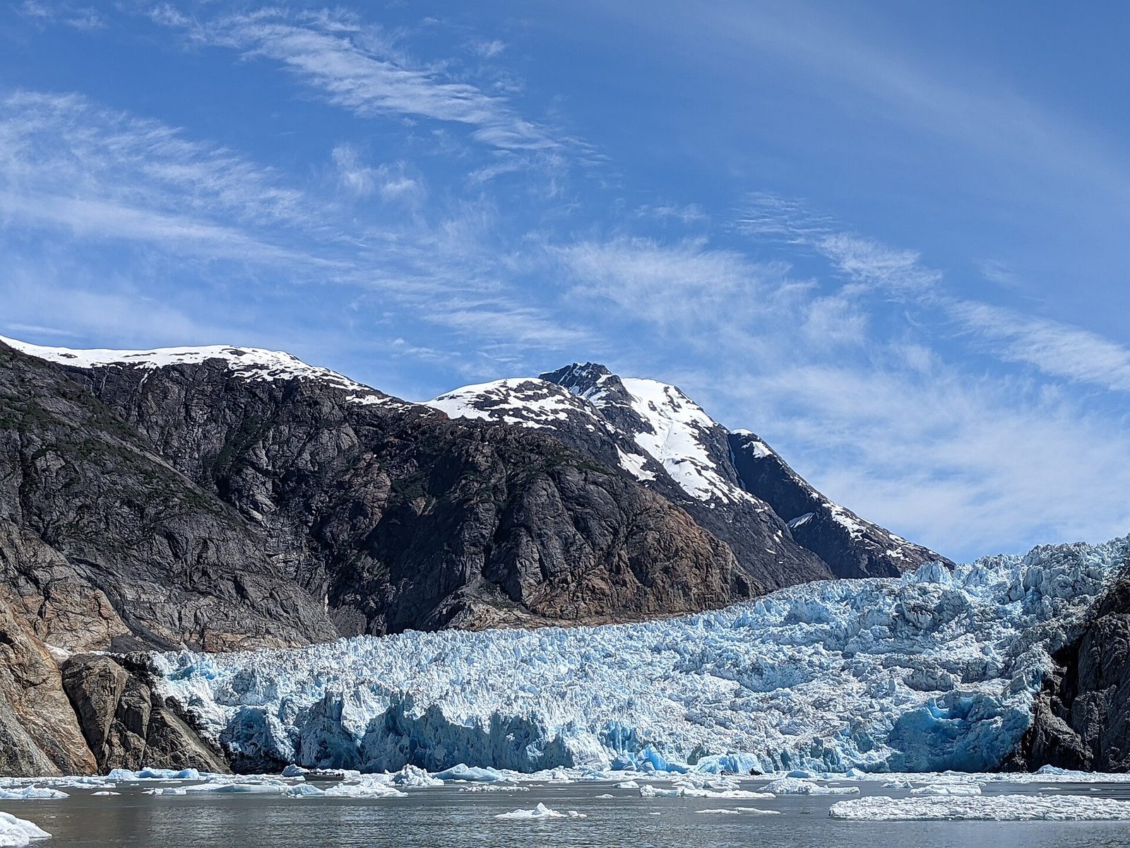 Sawyer Glacier meeting the water at the head of Tracy Arm under snow-capped peaks