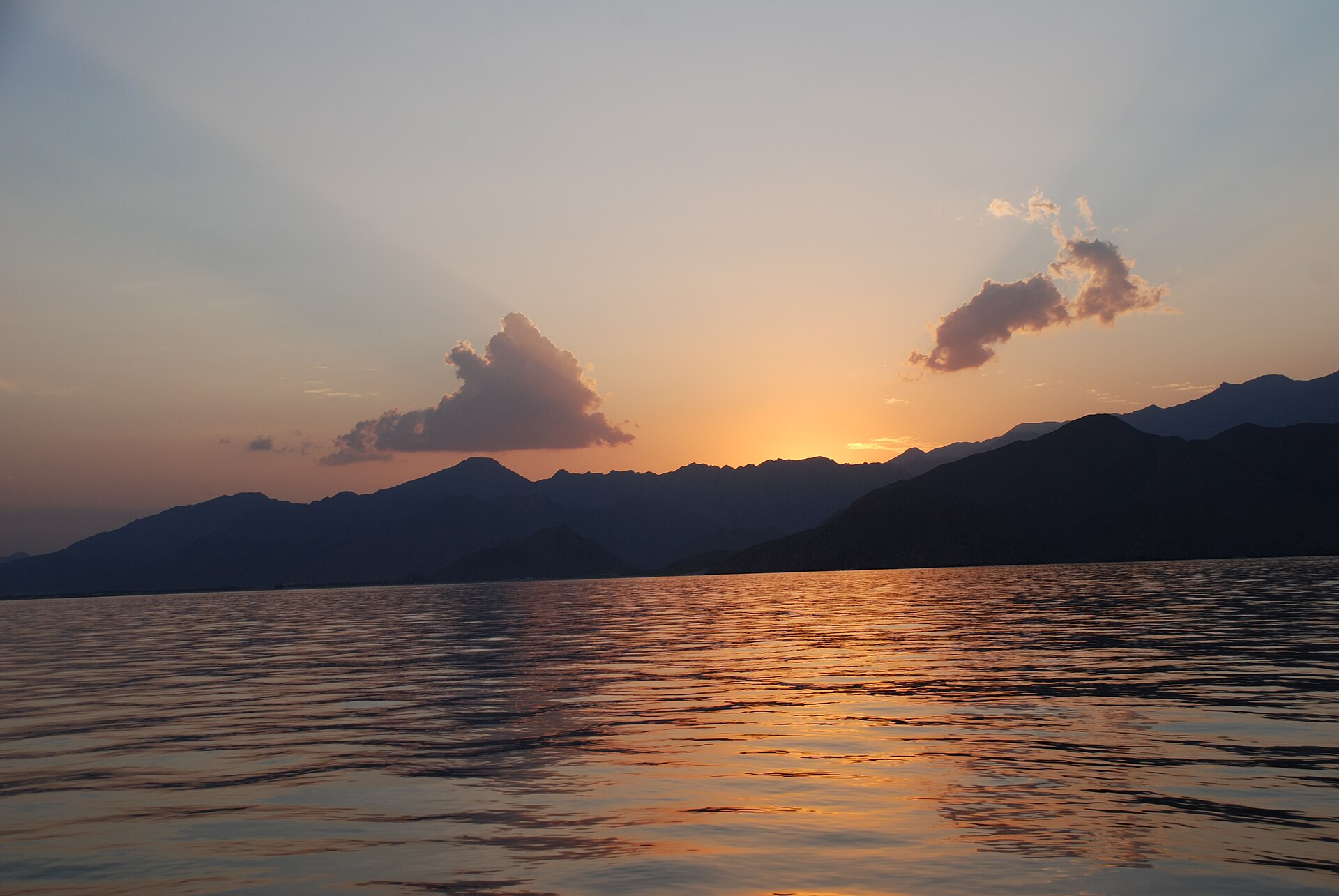 Sunset over the mountains and calm water of the Musandam Peninsula, Oman