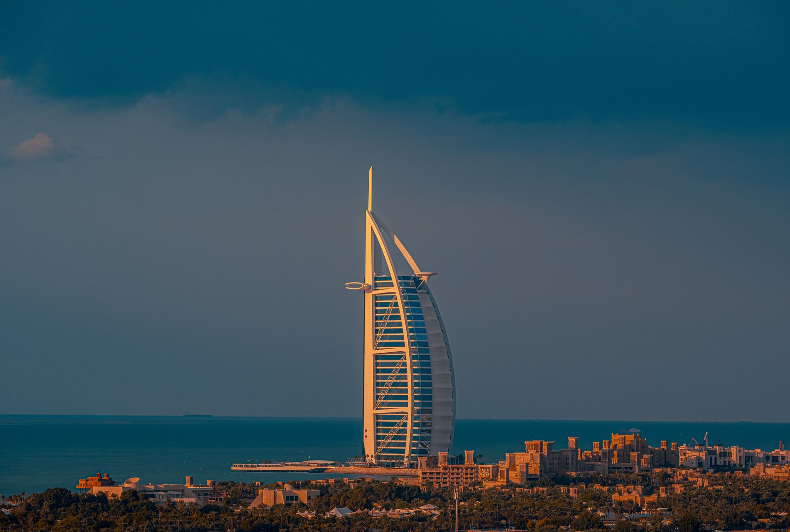 The Burj Al Arab silhouetted against a dramatic sunset sky
