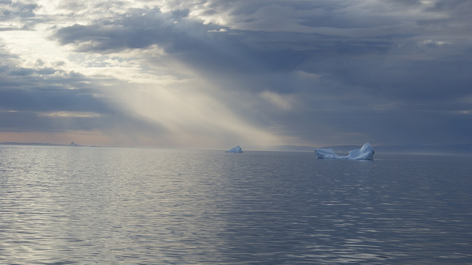 Sunlight breaking over icebergs in central Disko Bay, Greenland