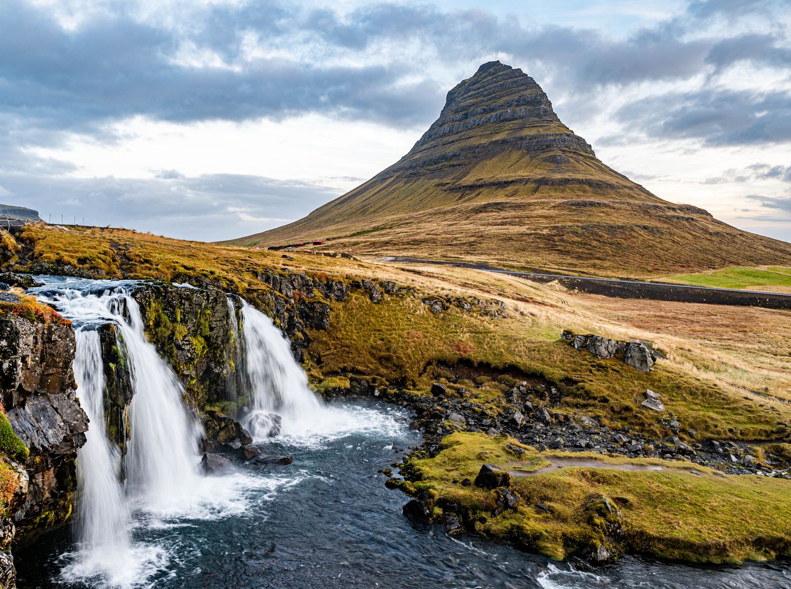Kirkjufell rising over Grundarfjörður with cascading falls in the foreground