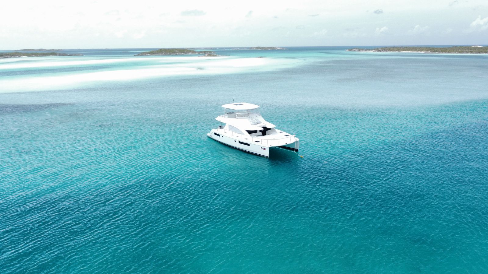 Aerial view of a yacht at anchor in turquoise water