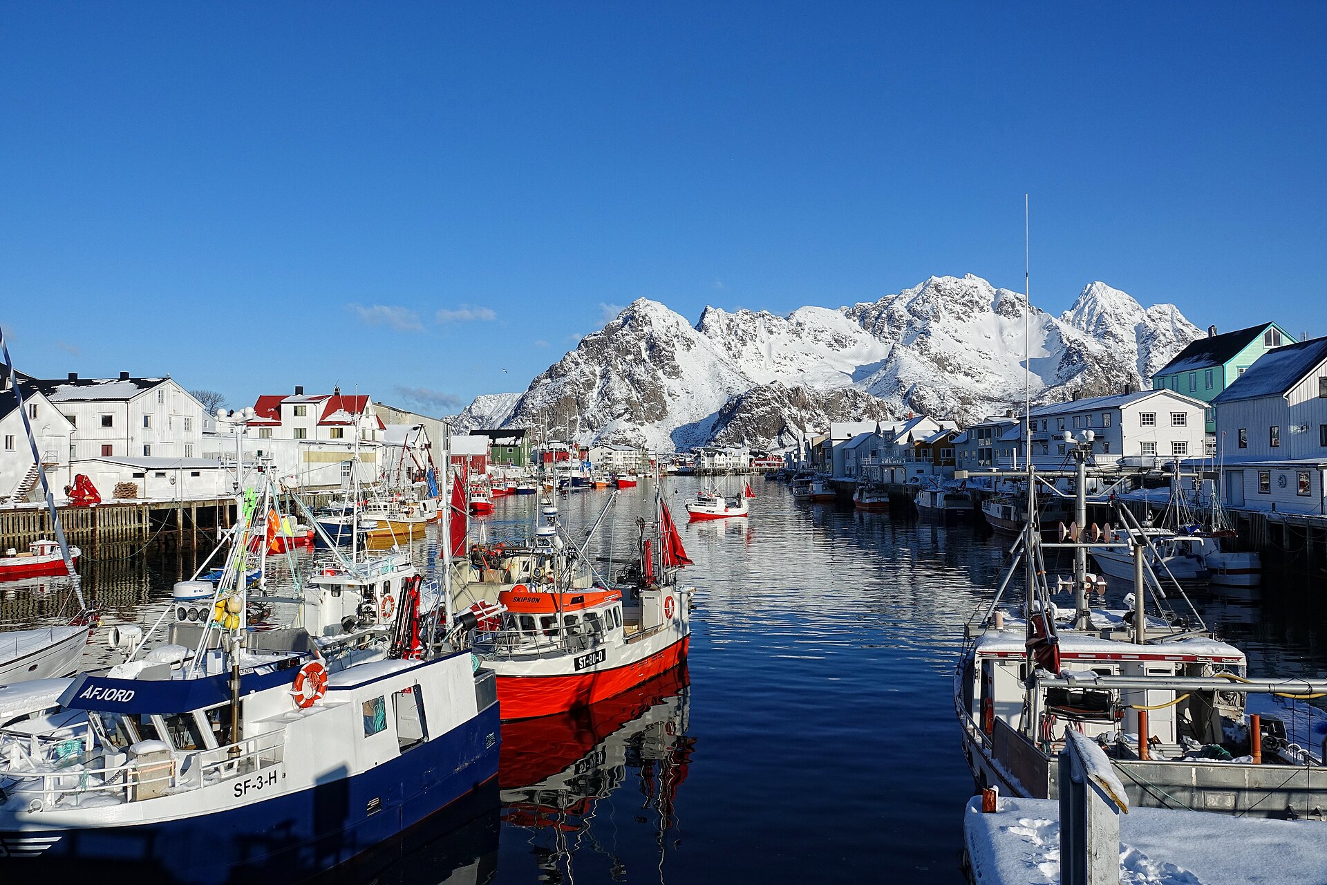 Henningsvær village spread across its skerries at the foot of Vågakallen