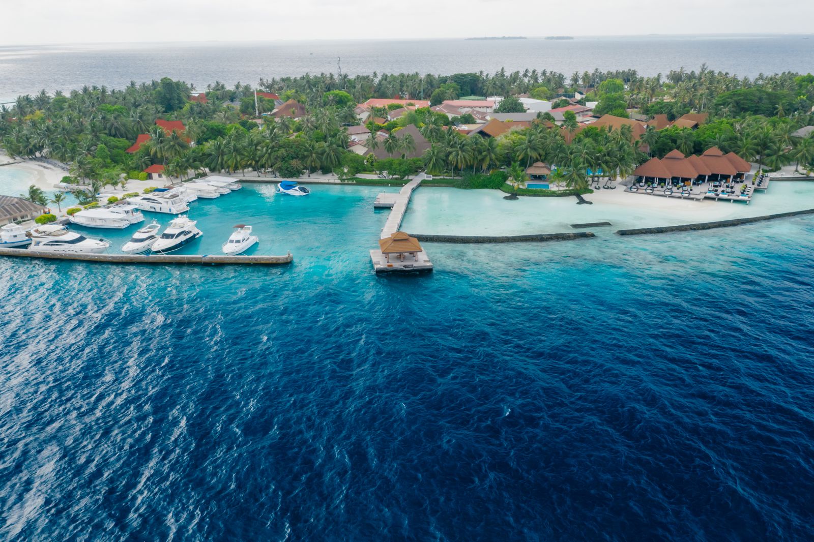 Aerial view of yachts moored beside a Maldives resort lagoon