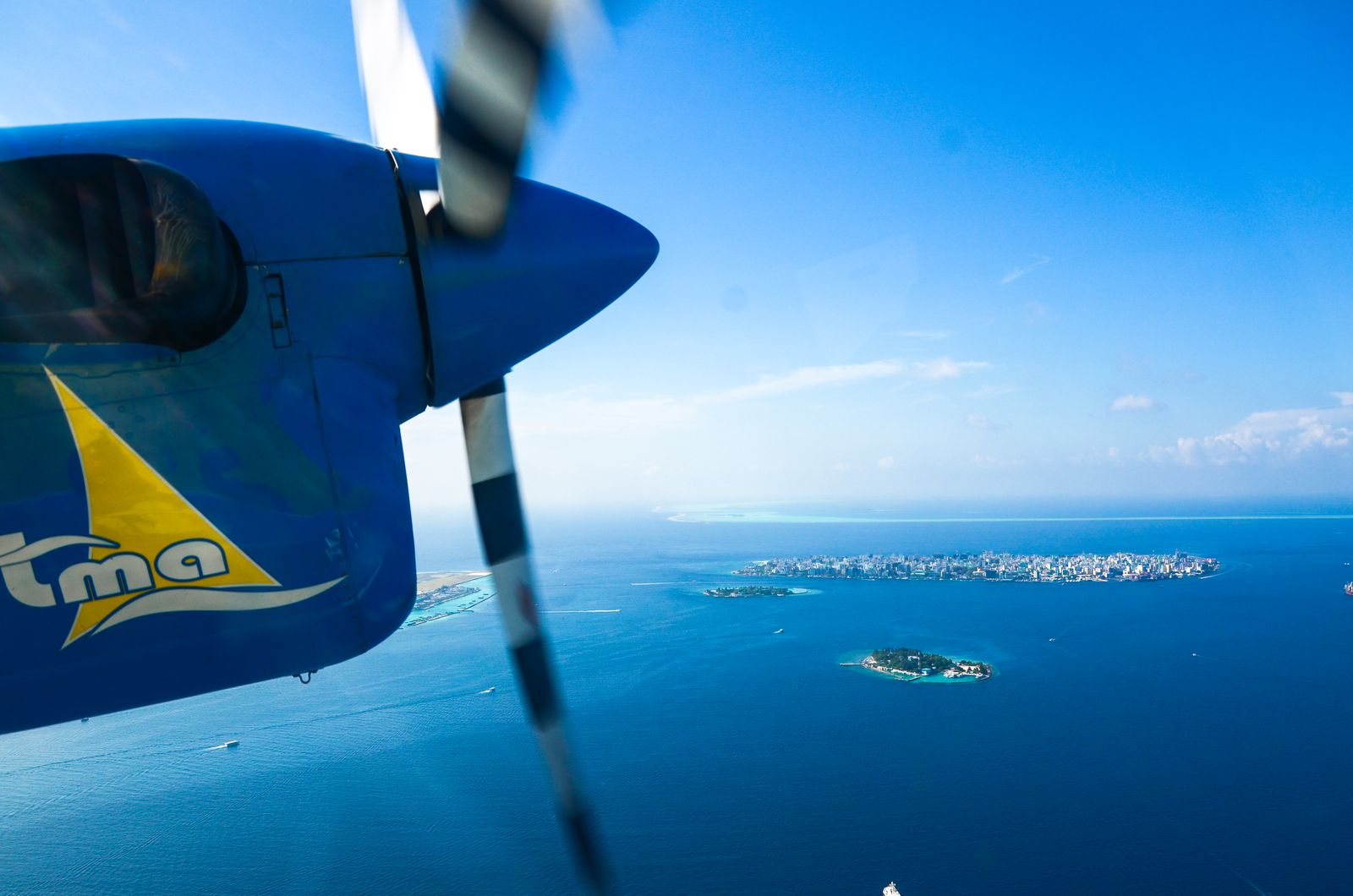 Seaplane flying over the Maldives' turquoise atolls
