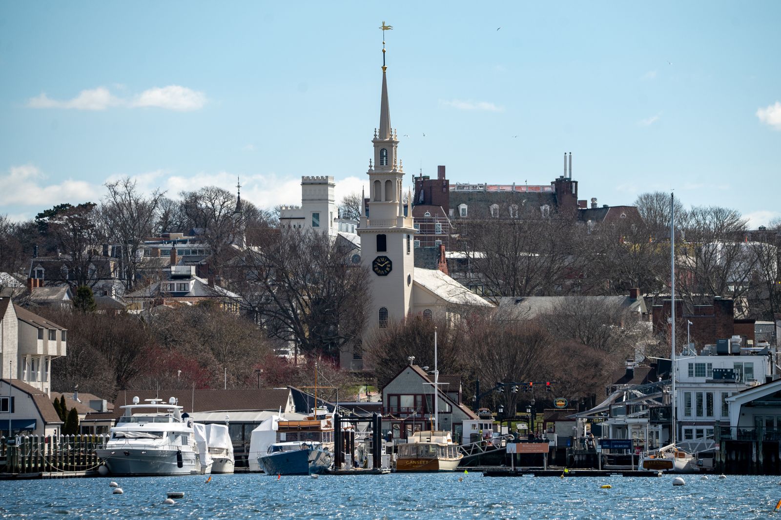 Newport harbour waterfront with a historic church spire rising behind the masts