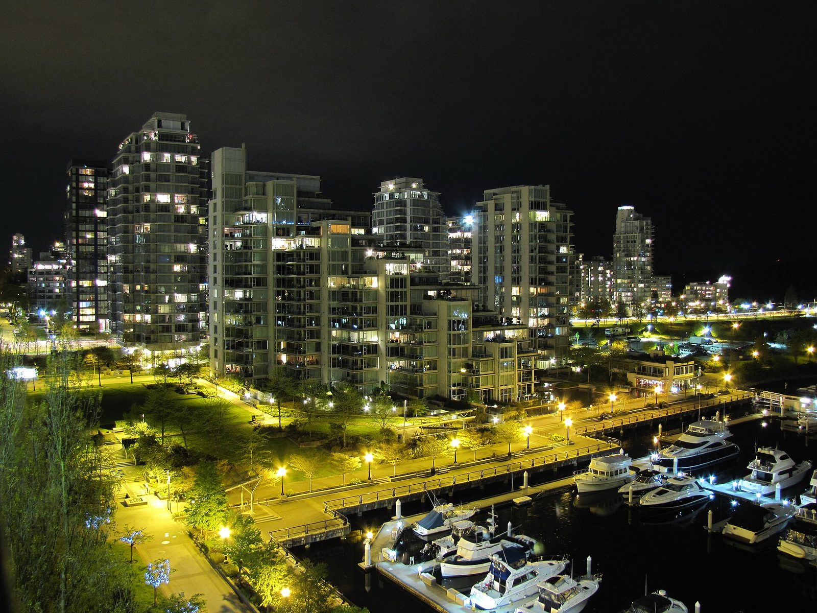 Yachts moored at Coal Harbour marina beneath Vancouver's downtown towers at night