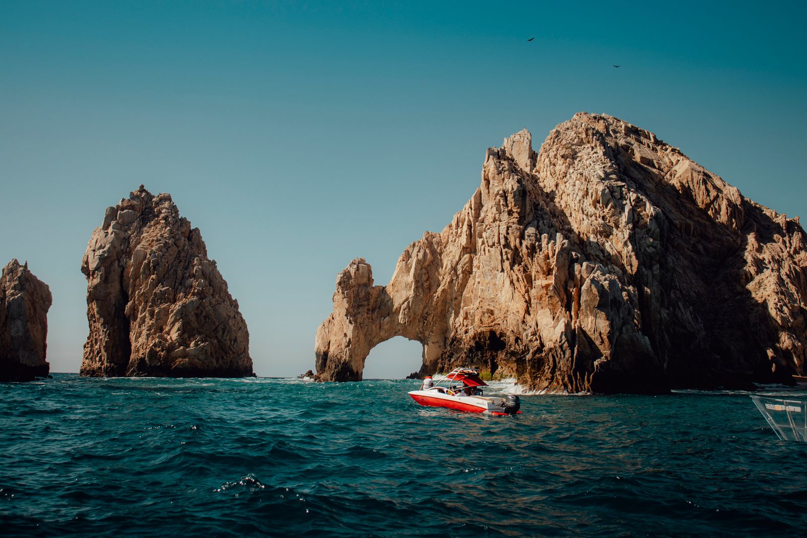 The arch at Land's End, Cabo San Lucas, with a boat passing beneath the cliffs